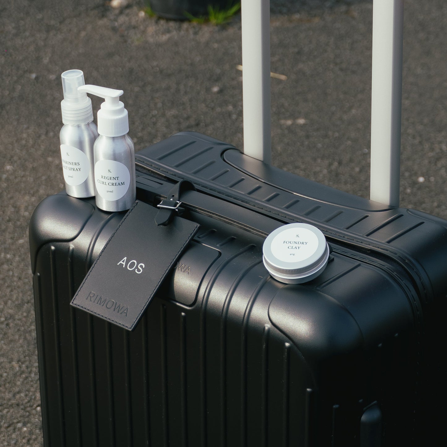 Black suitcase with travel bottles on a dark surface