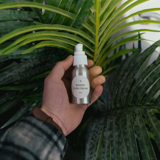 Hand holding a curl cream bottle